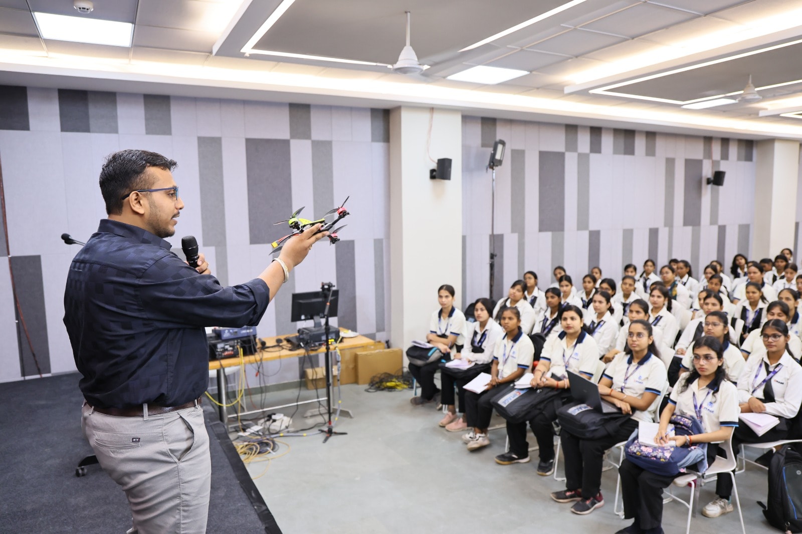 Instructor holding a drone during a classroom demonstration