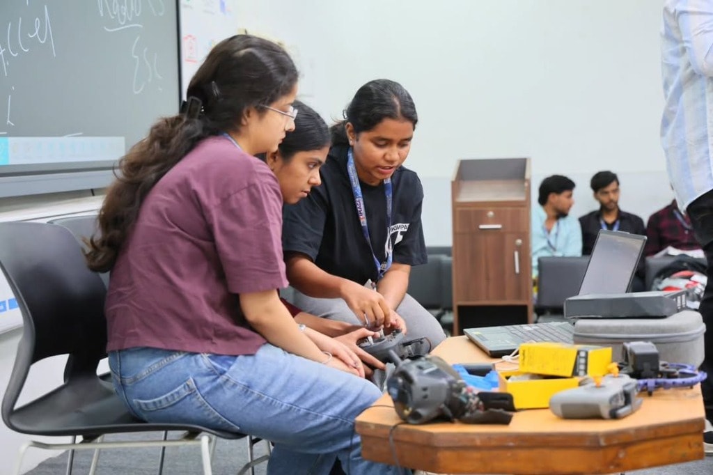 Workshop participants assembling and examining drone hardware together